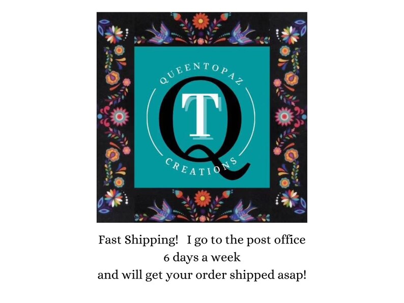 May include: A square logo featuring a teal center with a large black letter Q and a white letter T inside. The text QUEENTOPAZ CREATIONS is arched around the letters. A black border surrounds the center with colorful floral and bird patterns.