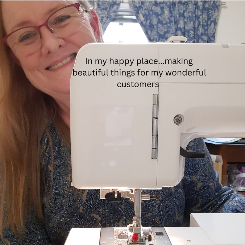 May include: A white sewing machine with the text "In my happy place...making beautiful things for my wonderful customers." The machine is in use, with the needle and presser foot visible. The background includes a person wearing glasses.