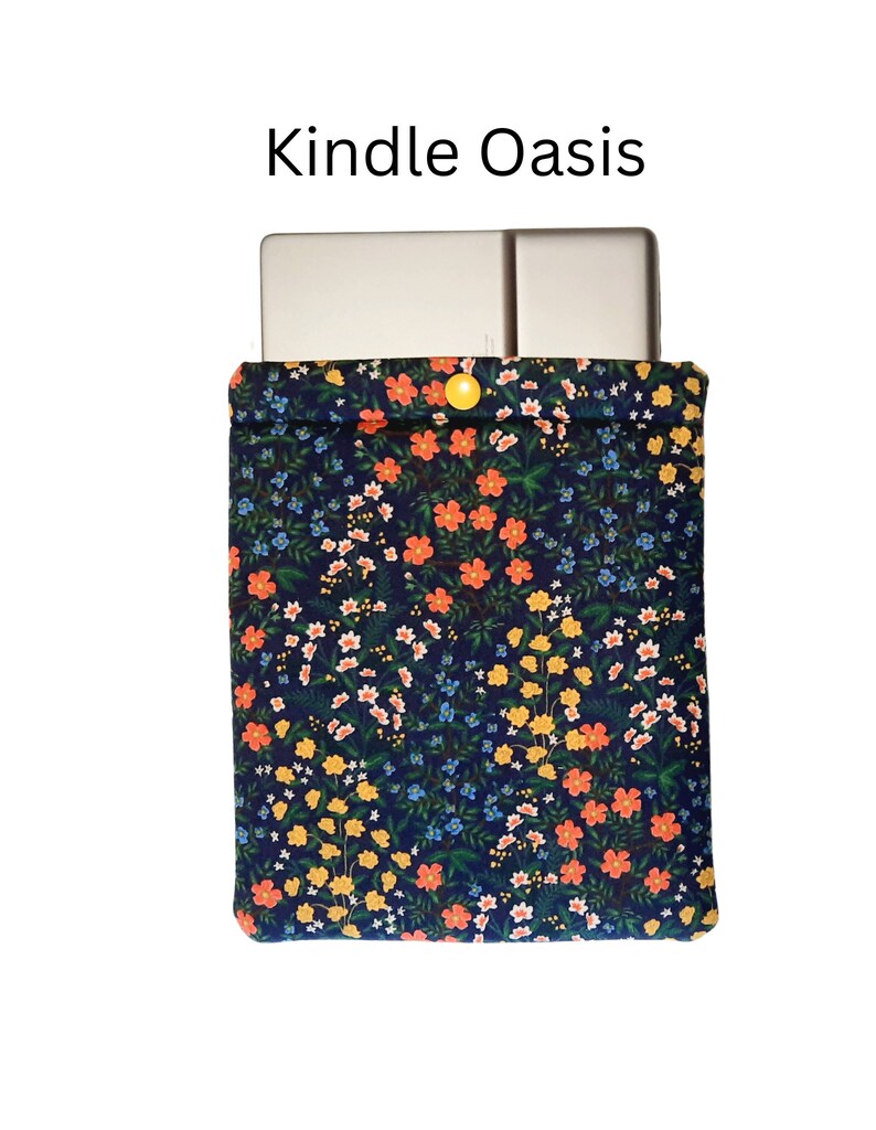 May include: A Kindle Oasis case featuring a navy blue floral design. The fabric case has a yellow button fastening. The words "Kindle Oasis" are printed above the case.