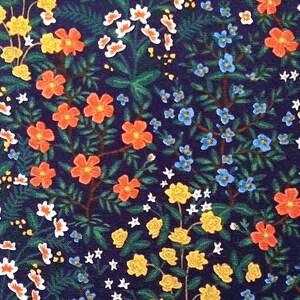 May include: A floral pattern on a dark navy blue background. The design includes orange, yellow, white, and blue flowers, along with green leaves and stems. The pattern is densely packed with botanical elements.