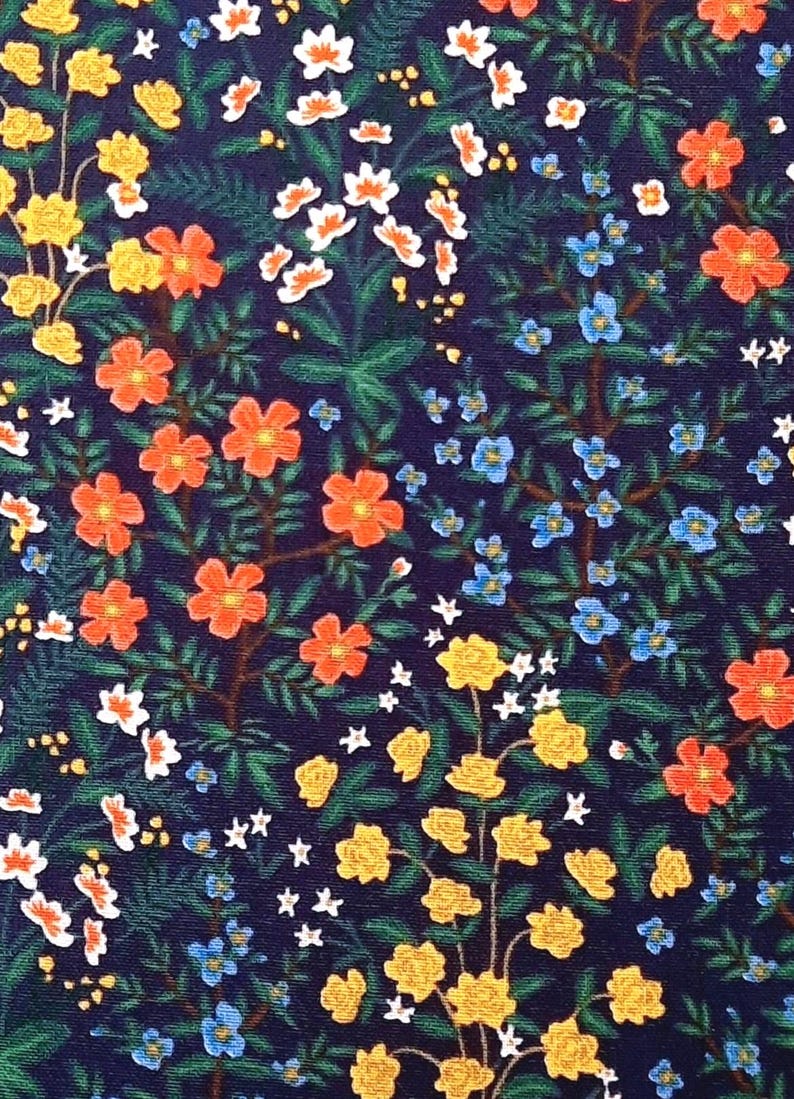 May include: A floral pattern on a dark navy blue background. The design includes orange, yellow, white, and blue flowers, along with green leaves and stems. The pattern is densely packed with botanical elements.
