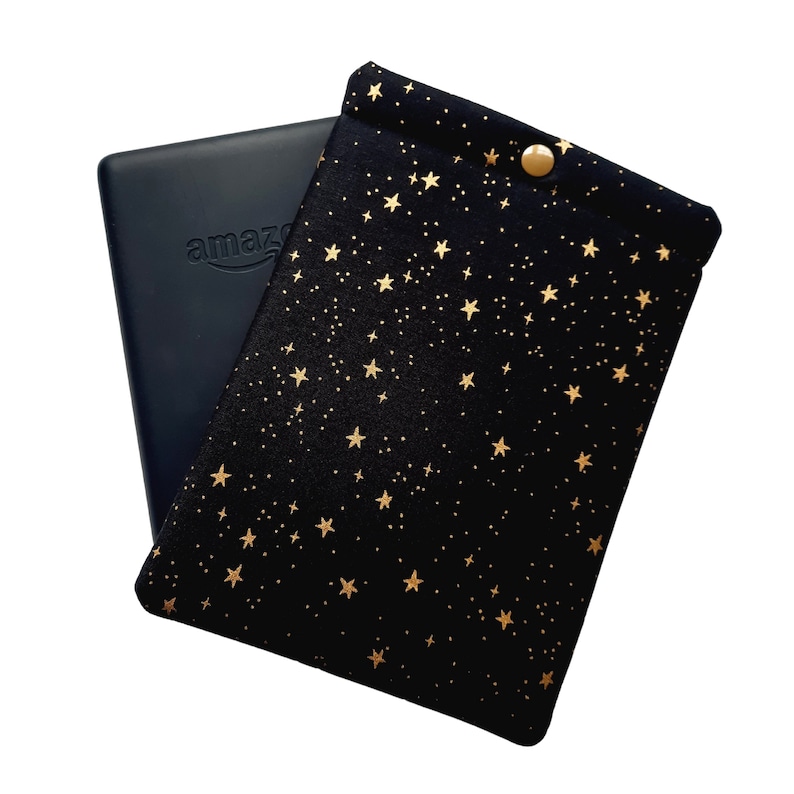Puede incluir: Funda negra para lector electr&oacute;nico con un patr&oacute;n de estrellas doradas. La funda tiene un cierre de bot&oacute;n.