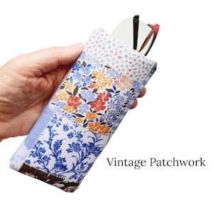 Pu&ograve; includere: Un astuccio per occhiali patchwork rettangolare con un motivo floreale rosso, blu e arancione. La custodia presenta una variet&agrave; di motivi in tessuto. Il testo "Vintage Patchwork" &egrave; stampato in basso a destra.