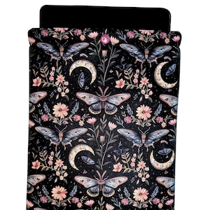 May include: Black phone case with a repeating pattern of blue butterflies, crescent moons, and pink flowers. The design is set against a dark background, creating a celestial and whimsical aesthetic. The case has a black top.