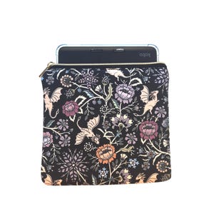May include: Black zippered tablet sleeve with a floral and dragon pattern. The design features dragons, flowers, and foliage in shades of pink, purple, orange, and white. A Kobo tablet is visible inside the sleeve.