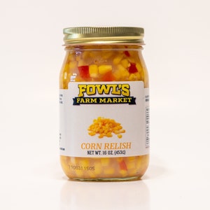 May include: A glass jar of yellow corn relish with red peppers. The jar has a white label with the text "FOWL'S FARM MARKET" and "CORN RELISH NET WT. 16 OZ. (453G)".