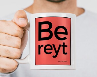 May include: White ceramic mug with a red square design. The square has black text that reads "Be reyt" and the words "we're yorkshire" in smaller black text below.