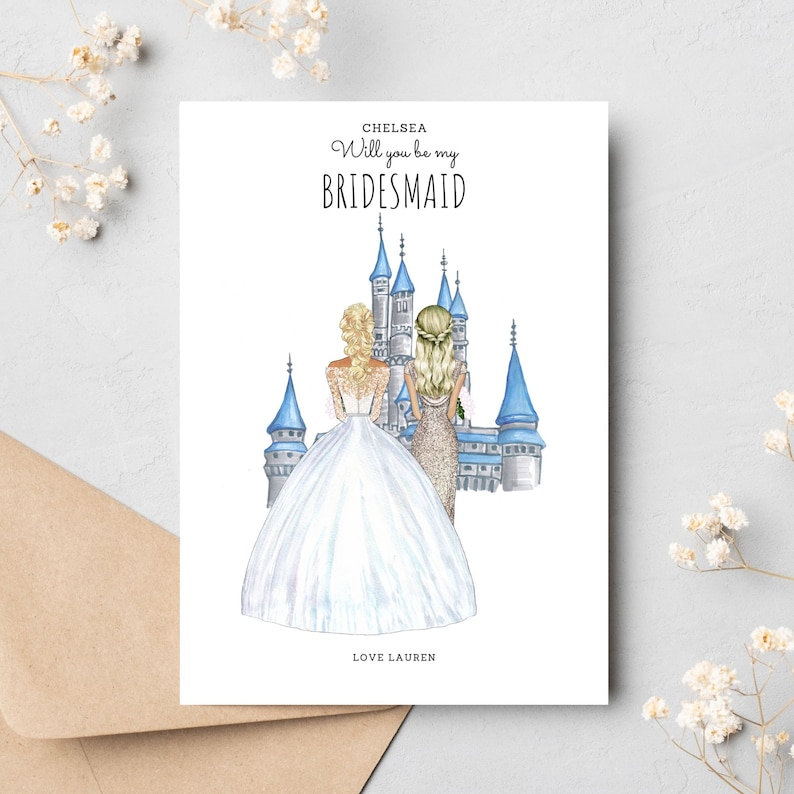 May include: A white card with blue and gray illustrations of a castle. The text on the card reads "Chelsea Will you be my BRIDESMAID LOVE LAUREN".