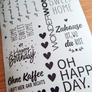 Könnte beinhalten: Eine Blatt mit schwarzen und weißen Aufklebern mit verschiedenen Sprüchen und Designs. Die Aufkleber beinhalten "Home Sweet Home", "Wonder Woman", "Happy Birthday", "Ohne Kaffee Läuft Hier Gar Nichts", "Zuhause Ist Wo Du Bist", und "Oh Happy Day".