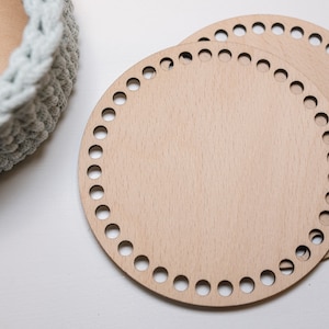 K&ouml;nnte beinhalten: Zwei runde Holz-Stricknadeln mit L&ouml;chern am Rand. Die Stricknadeln sind aus hellem braunem Holz und &uuml;bereinander gestapelt.