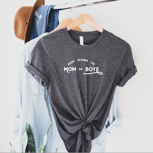 Könnte beinhalten: Ein dunkelgraues T-Shirt mit weißem Text, der "Messy Blessed Life Mom of Boys" lautet.
