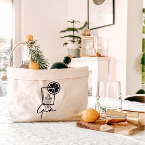 Könnte beinhalten: Eine weiße Stofftasche mit einer schwarzen Grafik eines Gin-Glases mit einer Zitronenscheibe. Der Text auf der Tasche lautet "Gib deinem Leben einen Gin".