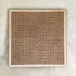 May include: A wooden puzzle featuring a complex, intricate pattern of interlocking shapes. The puzzle is made from light brown wood and is square in shape.