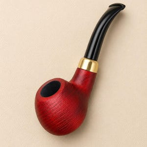 May include: A tobacco pipe featuring a deep red wooden bowl with a visible grain texture, a polished gold-colored metal band connecting the bowl to the stem, and a smooth, curved black acrylic mouthpiece extending from the top of the pipe.