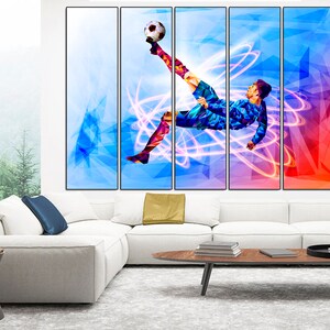 May include: A multi-panel canvas print featuring a soccer player kicking a ball in mid-air. The player is silhouetted against a colorful background of blue, pink, and red geometric shapes. The image is dynamic and energetic, capturing the excitement of the sport.