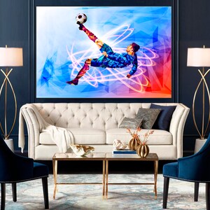 May include: A white sofa with a white throw blanket and two blue armchairs in a living room with a large abstract painting of a soccer player kicking a ball. The painting has a blue, red, and white color scheme.