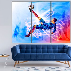 May include: A colorful abstract painting of a soccer player kicking a ball. The player is in mid-air, with their leg extended and their foot about to make contact with the ball. The background is a mix of blue, red, and white, with geometric shapes and lines.