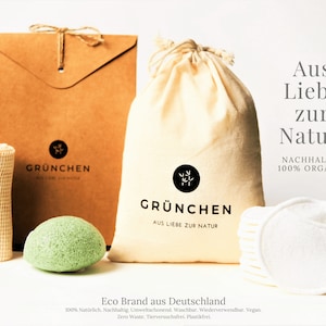 Könnte beinhalten: Ein Set an umweltfreundlichen Badezimmerutensilien, bestehend aus einem grünen Konjakschwamm, einem weißen Wattepad, einem weißen Netzbeutel und einem braunen Papierumschlag mit dem aufgedruckten Text "GRÜNCHEN AUS LIEBE ZUR NATUR". Der Text "Aus Liebe zur Natur. NACHHALTIG 100% ORGANIC" ist ebenfalls auf dem Bild zu sehen. Der Text "Eco Brand aus Deutschland 100% Natürlich. Nachhaltig. Umweltschonend. Waschbar. Wiederverwendbar. Vegan. Zero Waste. Tierversuchsfrei. Plastikfrei." ist am unteren Rand des Bildes gedruckt.