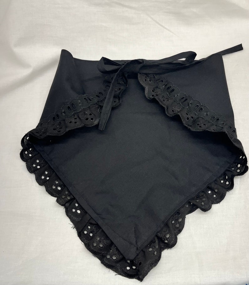 Puede incluir: Bandana de algod&oacute;n negro con ribete de encaje y cierre de lazo.