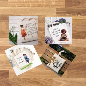 May include: Four tote bags with inspirational quotes and illustrations of Black women. The quotes are: "A woman who walks with God always reaches her destination", "Study to show yourself approved unto God 2 Timothy 2:15", "Created for Purpose", and "As for me and my house, we will serve the Lord Joshua 24:15".