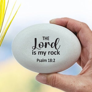May include: White oval-shaped stone with the text "THE Lord is my rock Psalm 18:2" in black lettering.