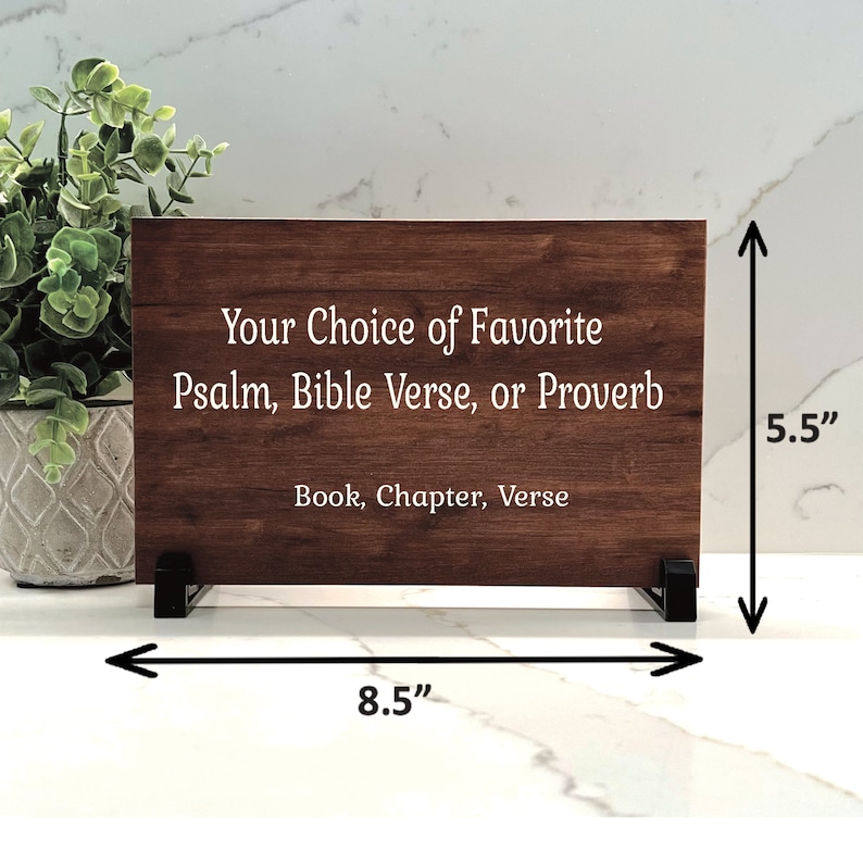Pode incluir: Uma placa de madeira com uma mancha marrom, medindo 8,5 polegadas de largura e 5,5 polegadas de altura, com o texto "Your Choice of Favorite Psalm, Bible Verse, or Proverb Book, Chapter, Verse" em letras brancas.