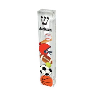 May include: A clear acrylic sports themed personalized bar mitzvah or bat mitzvah  candle holder with the name "Jackson" and a Star of David. The holder features a baseball, football, basketball, soccer ball, and a baseball bat.