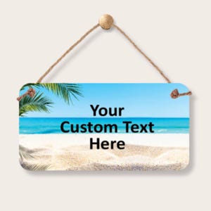 May include: A white ceramic mug with a black handle and the text "But First, Coffee" in a black, bold font. The mug is sitting on a wooden surface. The mug is 4 inches tall.