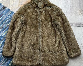 May include: A brown faux fur jacket with a high collar and a zipper closure.