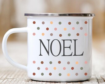 May include: White enamel mug with a polka dot pattern in shades of brown, pink, and green. The word "NOEL" is printed in black on the mug.