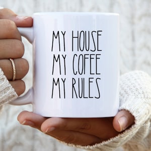 May include: White ceramic coffee mug with black text that reads "My house, my coffee, my rules".