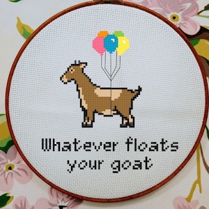 May include: A brown goat with a white patch on its belly is holding onto a bunch of colorful balloons. The text "Whatever floats your goat" is written below the goat.