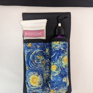 May include: A black canvas belt with a buckle and a black canvas pouch with a Starry Night print. The pouch has two pockets and a clear plastic tube with the word "BIOTOME" printed on it. The pouch also has a purple pump bottle.