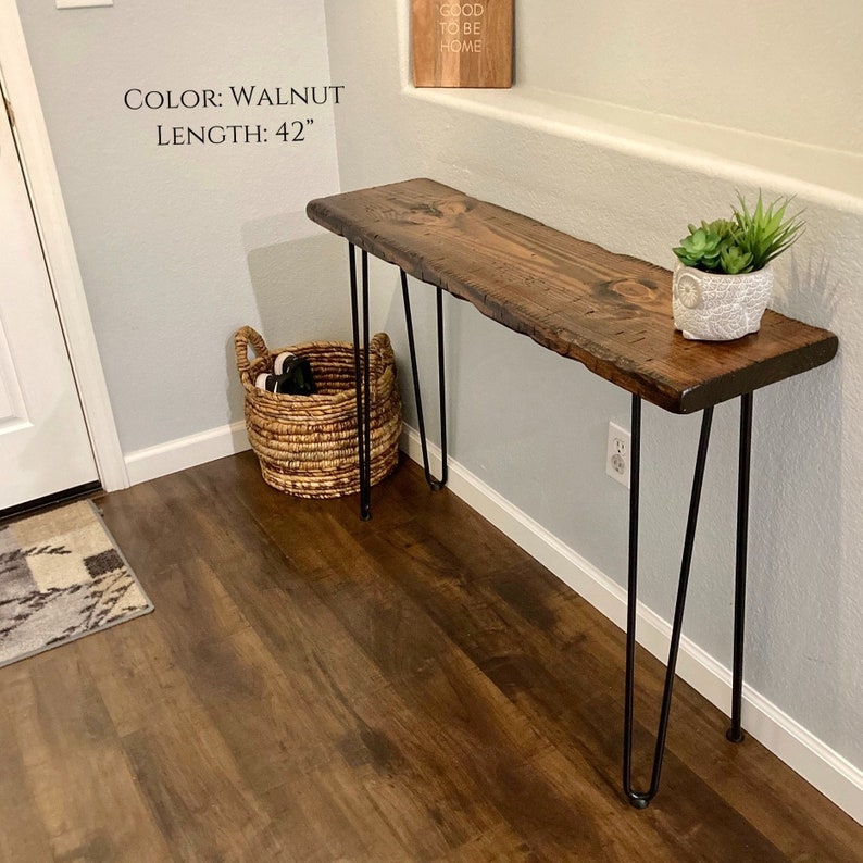 Puede incluir: Una mesa consola de madera de nogal con patas de horquilla negras. La mesa tiene 42 pulgadas (106,68 cm) de largo. La mesa est&aacute; en un ambiente hogare&ntilde;o con una cesta y una planta en maceta en la parte superior.