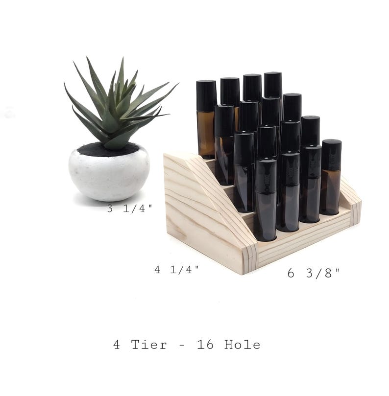 May include: A wooden, 4-tier display stand with 16 holes, holding several amber and black roller bottles. The stand measures 6 3/8 inches wide, 4 1/4 inches deep. A small succulent in a white pot is to the left. The text reads: 4 Tier - 16 Hole.