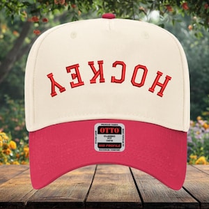 May include: Cream and red baseball cap with the word "HOCKEY" embroidered in red. The cap features a curved peak and a small red button on top. The "OTTO" brand tag is visible on the front.