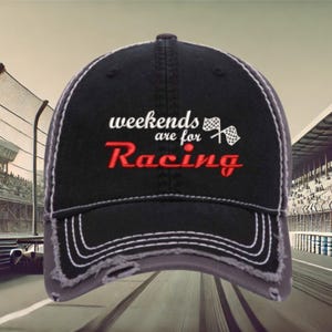 May include: A black and gray distressed baseball cap with the text "weekends are for Racing" and a checkered flag graphic embroidered on the front.