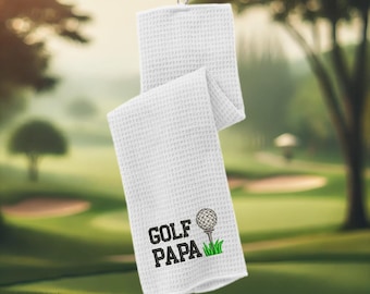 May include: White golf towel with the text "GOLF PAPA" and an embroidered golf ball on a tee.