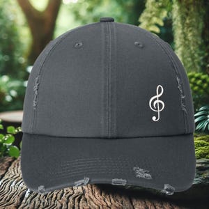 May include: A dark gray distressed baseball cap with a white treble clef embroidered on the front.