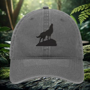 May include: A gray denim baseball cap with an embroidered silhouette of a wolf howling at the moon.