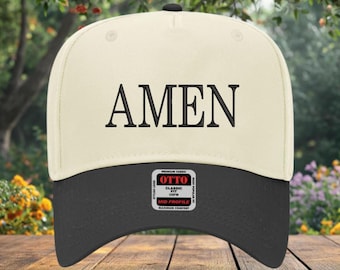 May include: A cream-colored baseball cap with a black brim and the word "AMEN" embroidered in black. The cap has a classic mid-profile design and a tag that reads "OTTO Classic".