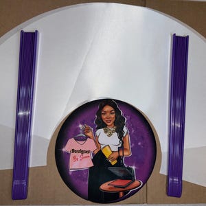 May include: A set of white heat press transfer sheets with purple heat press tools. The sheets are in a fan shape and the tools are stacked together. The image also includes a purple circle with a cartoon illustration of a woman with a heat press and the text "Designs By Sienna".