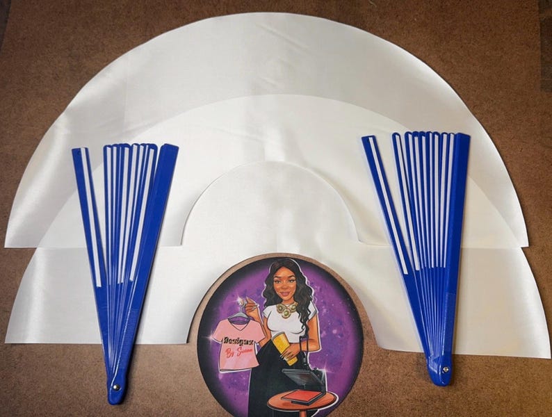 May include: Three white satin fabric fan bases with blue and white plastic fan sticks. The fan sticks are folded and ready to be opened. The fan bases are arranged in a circle with the fan sticks extending out from the center.