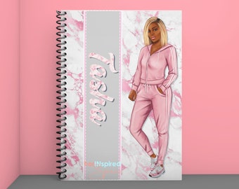 May include: Spiral-bound notebook with a pink marble design and the name "Tesha" in a floral font. The notebook features an illustration of a person in a pink tracksuit with white stripes. The text "her!Inspired" is also visible.
