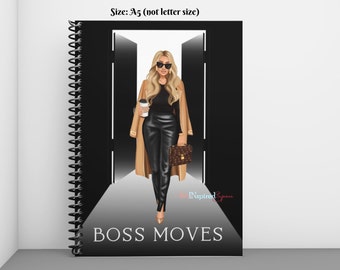 May include: A spiral-bound notebook with a black cover showing a woman in a tan coat and black trousers. The notebook has the words "BOSS MOVES" printed on the cover. The size is A5.