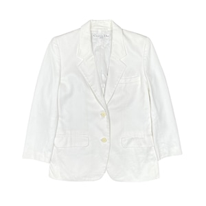 Puede incluir: Un blazer blanco con un patrón texturizado, con solapa de muesca, dos bolsillos delanteros y dos botones. La etiqueta dentro del blazer dice "Christian Dior". El blazer tiene mangas de tres cuartos.