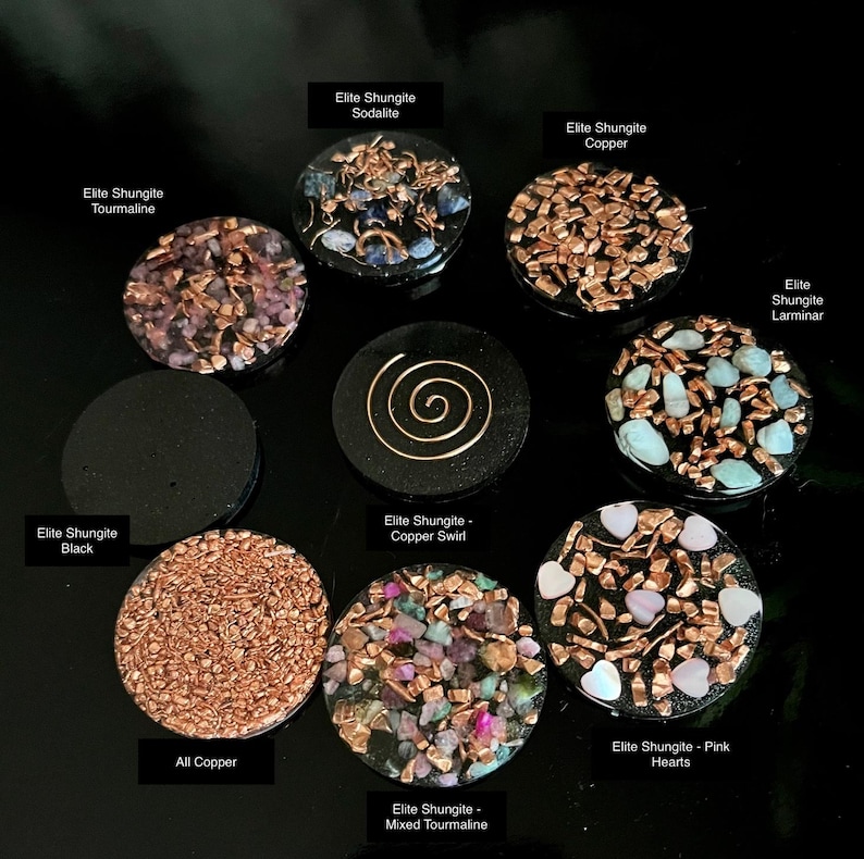 May include: A collection of Elite Shungite stones with various designs and materials. The stones include copper, tourmaline, sodalite, and pink hearts. Each stone is round and has a unique pattern, with text labels identifying each type.