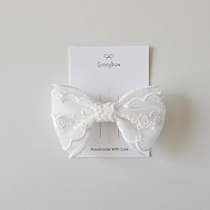 May include: White lace bow hair clip with the text "Sunnybow" and "Handmade With Love" on a white card.