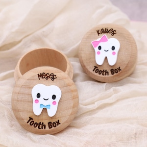 May include: Two wooden tooth boxes with a tooth design on the front. One box says "Moses Tooth Box" and the other says "Katies Tooth Box".