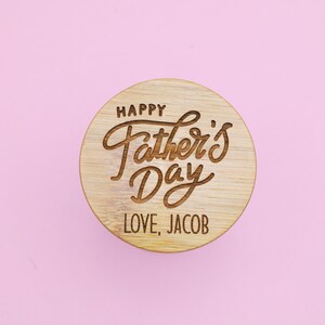 May include: A round wooden coaster with the text "Happy Father's Day" and "Love, Jacob" engraved on it.
